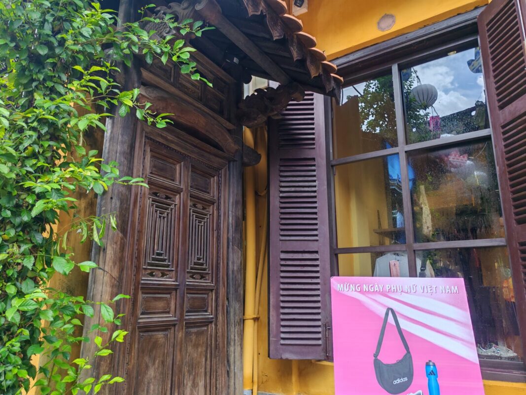 Wooden louvered shutters and yellow wall of the adidas store in Hoi An Ancient Town