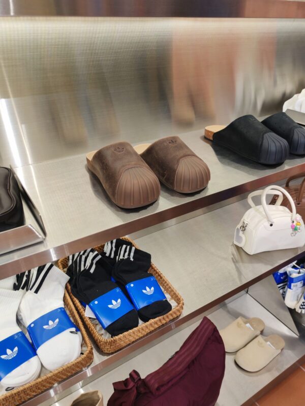 adidas slides in rattan baskets and a handbag on a shelf at the adidas store in Hoi An