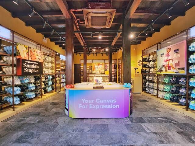 Inside the Crocs store in Hoi An: wooden beams, stone floor and a colourful Jibbitz display