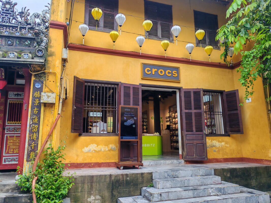 Crocs store in Hoi An in a yellow heritage house with a wooden sign