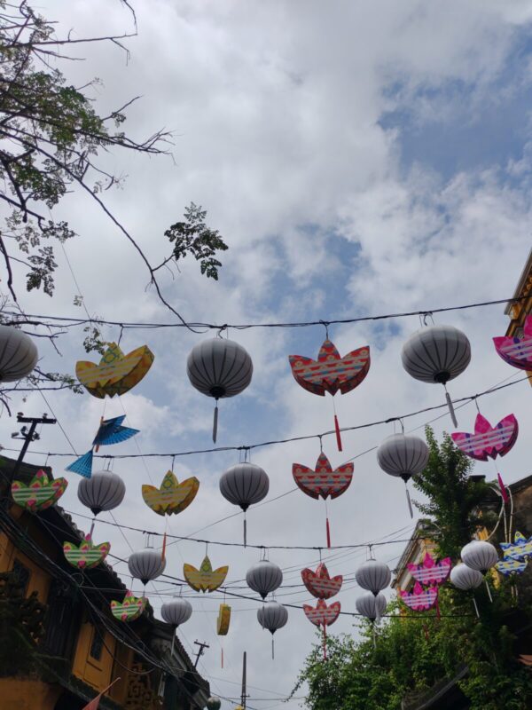 adidas Trefoil-shaped lanterns hanging between white silk lanterns in Hoi An
