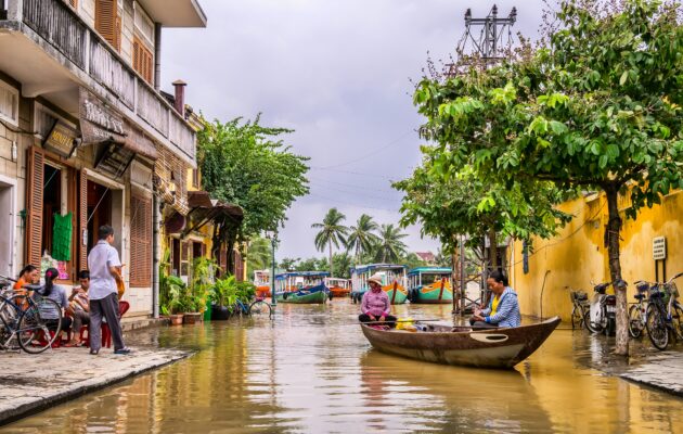 Flooded street in Hoi An Old Town with a small wooden boat