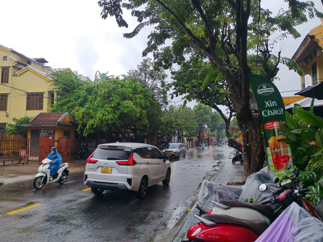 Rainy day on a Hoi An street with traffic moving normally